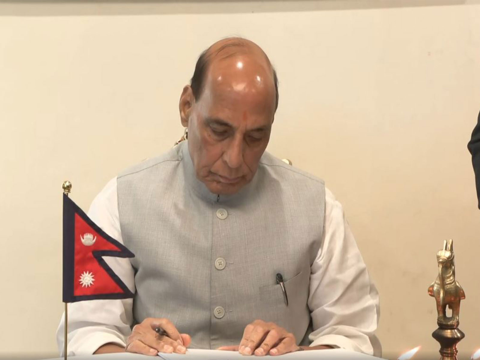 Defence Minister Rajnath Singh writes a message in the condolence book at the Nepal Embassy in New Delhi, expressing grief over the loss of lives and devastation caused by flash floods in Nepal (Photo/ANI)