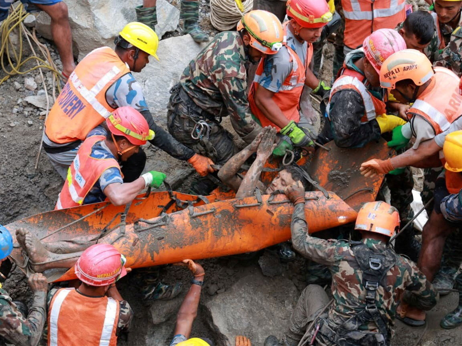 A survivor is carried by members of a search and rescue team after they rescued two people alive from a tunnel at the Trishuli-3A Hydropower Project (Photo/Nepal Army via Reuters)