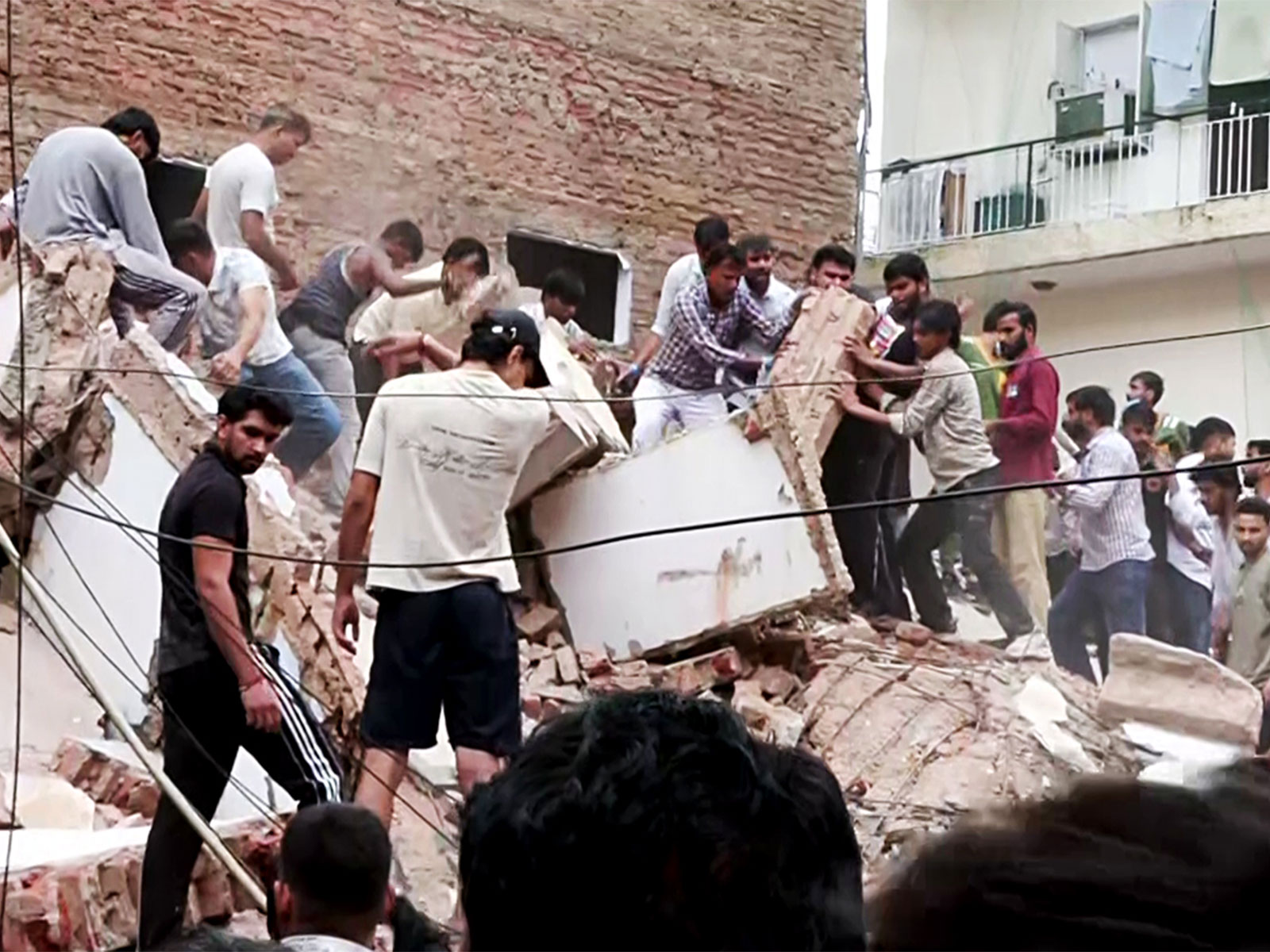 People remove debris during a rescue operation at the site of a building collapse near Satya Niketan in South-West Delhi (Photo/ANI)