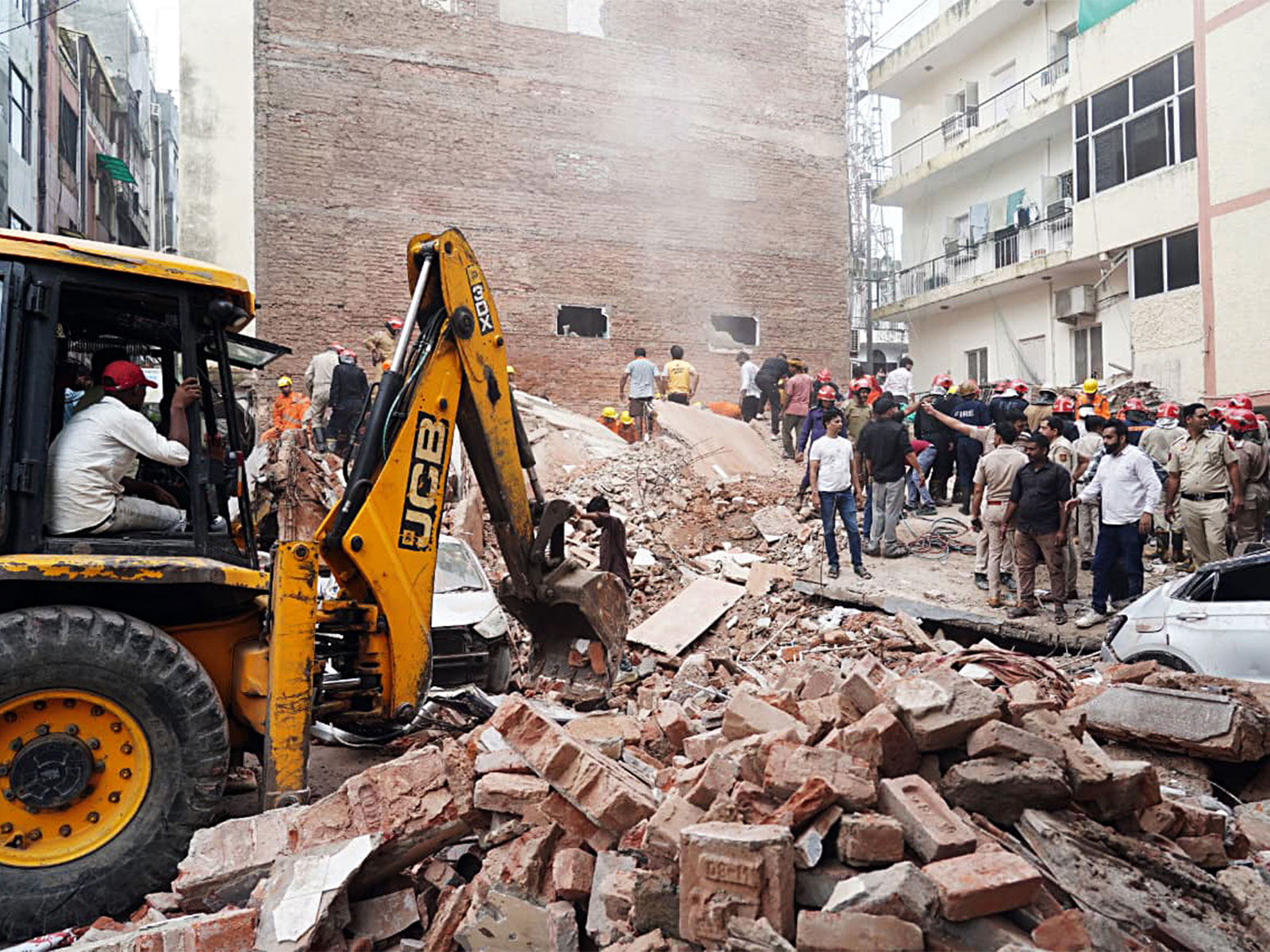 JCB machines carry out rescue operations at the site of a building collapse at Satya Niketan (Photo/ANI)