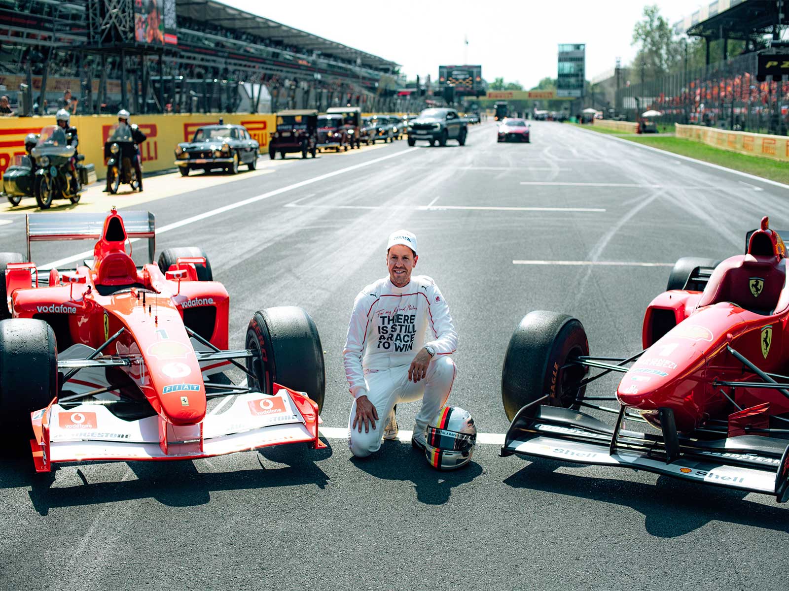 Sebastian Vettel poses with Michael Schumacher's F2002 and F310 cars on the grid at Monza. (Photo: X/ @F1)