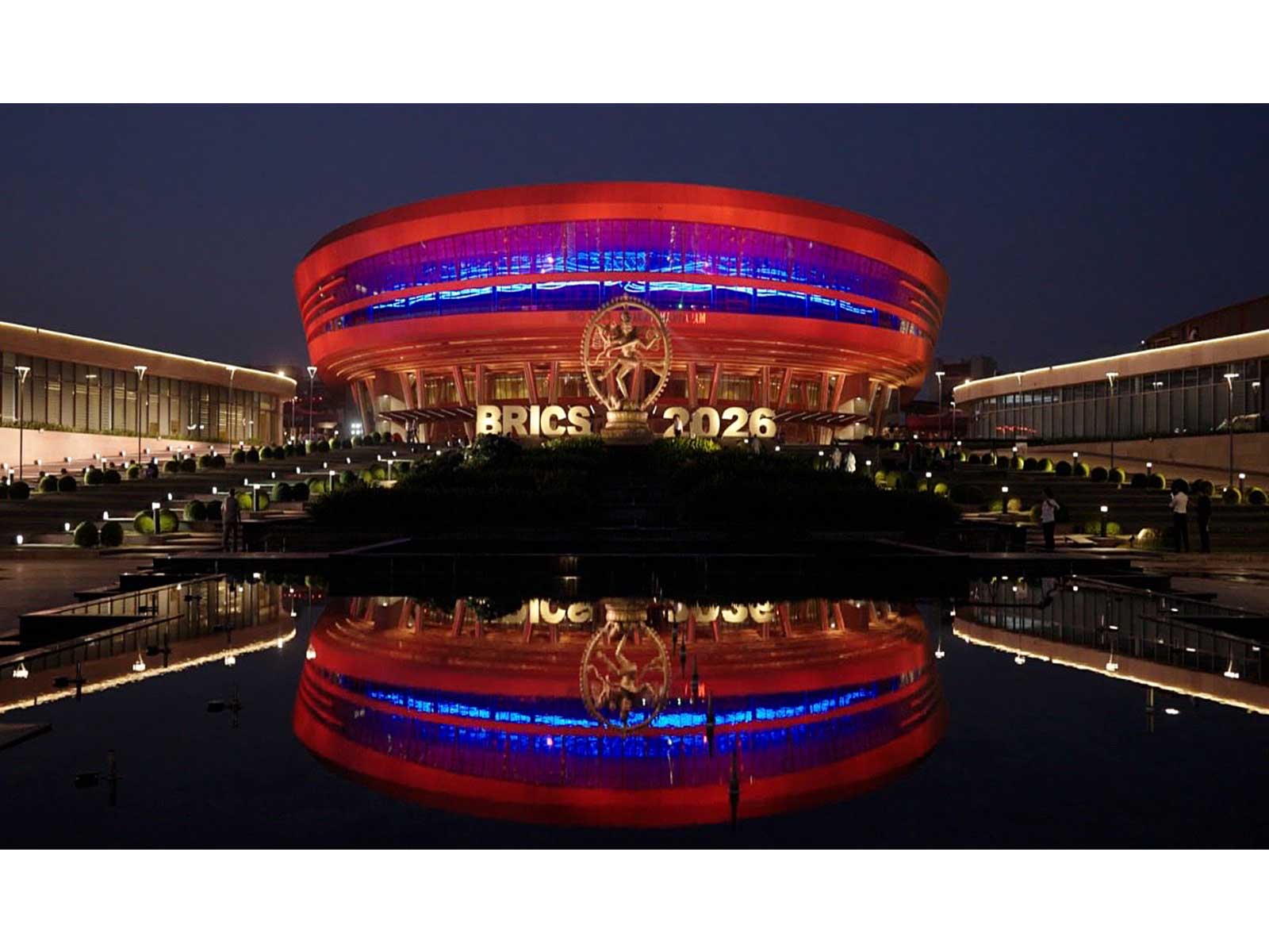 An illuminated view of Bharat Mandapam with colourful lights ahead of the BRICS Summit 2026, in New Delhi (Photo/X@MEAIndia)