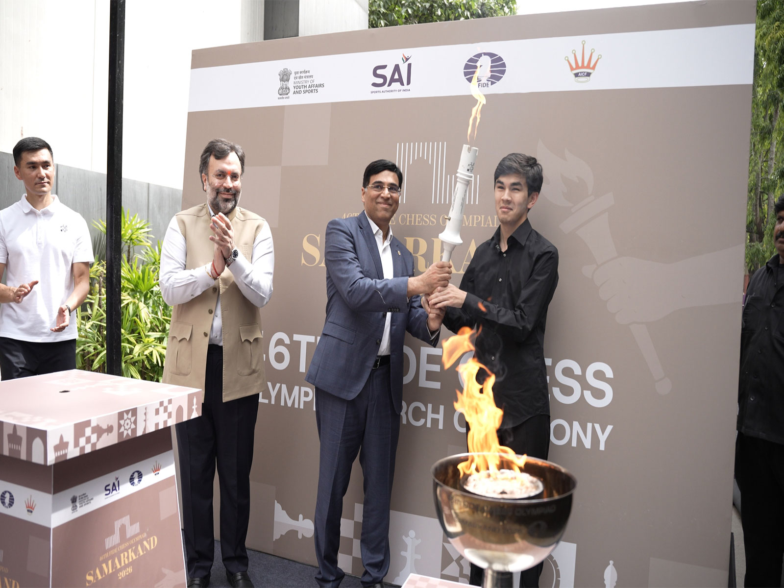 FIDE Interim President Viswanathan Anand hands over the ceremonial Olympiad torch to Uzbek GM Javokhir Sindarov. (Photo: AICF)
