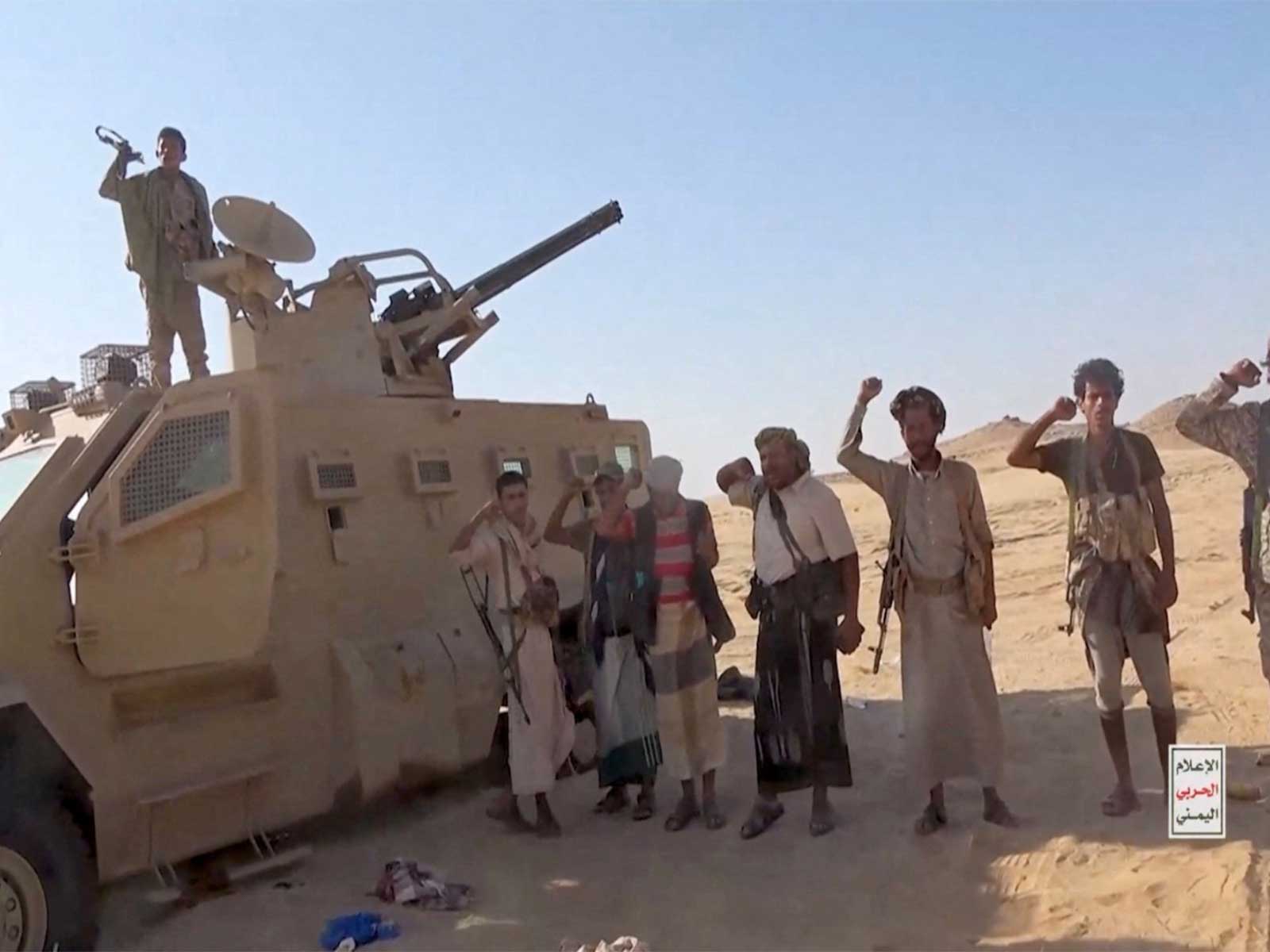 Houthi rebels in Yemen posing next to a captured vehicle (Photo/Reuters)