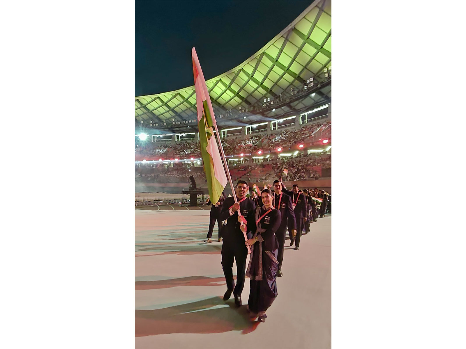 Manu Bhaker (R) with Kabaddi player Pawan Sehrawat were India's flag bearers at the Asian Games 2026 opening ceremony. (Photo: X/ @WeAreTeamIndia)