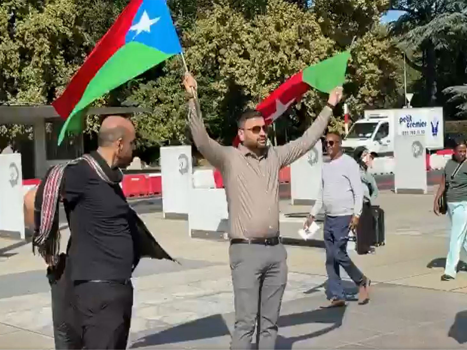 A demonstrator waves flags during the Baloch National Movement's anti-Pakistan rally in Geneva, protesting against state atrocities and human rights abuses in Balochistan. (Photo/ANI)
