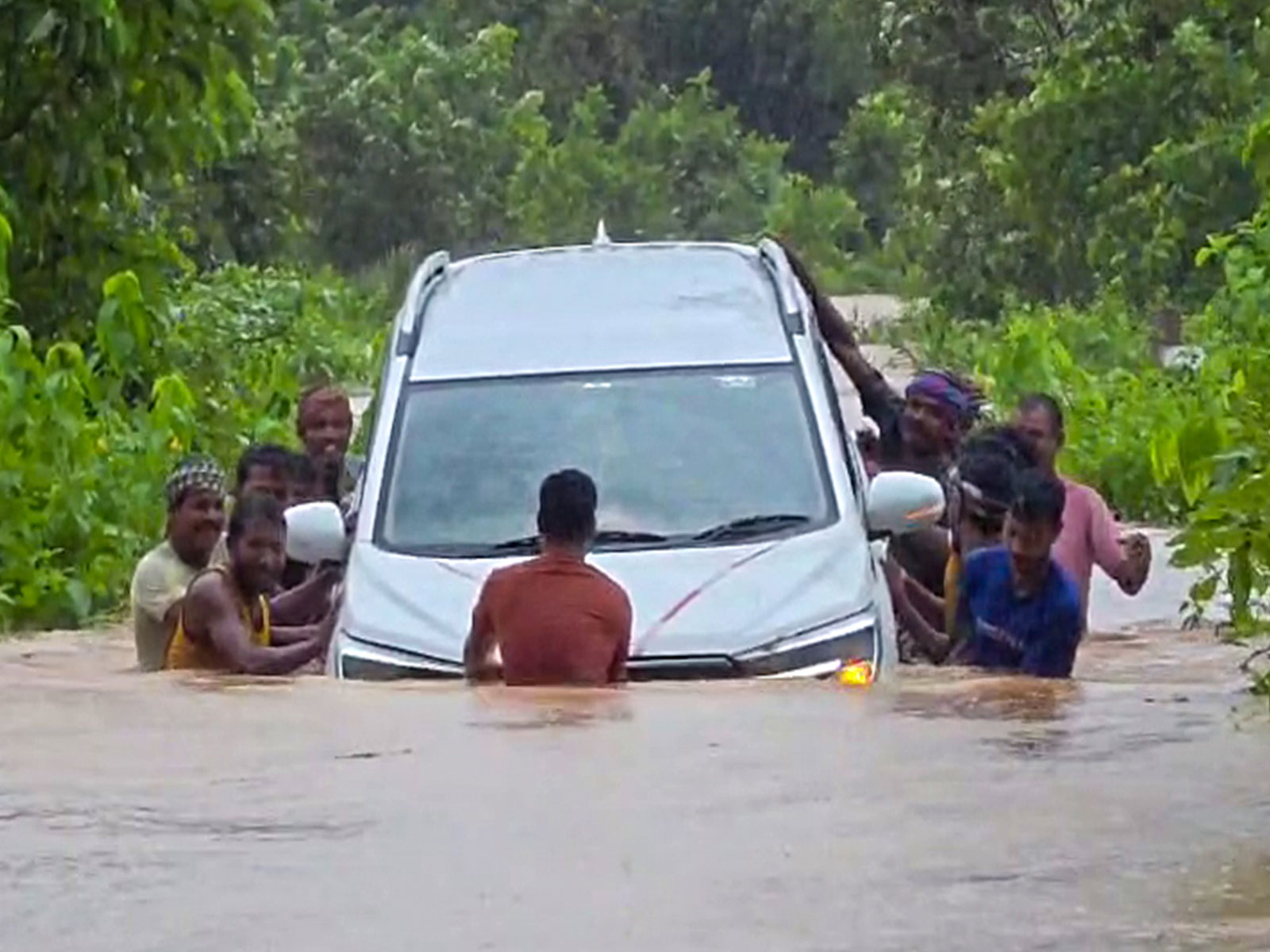 Locals wade through deep floodwaters to rescue stranded car in Odisha's Mayurbhanj (Photo/ANI)