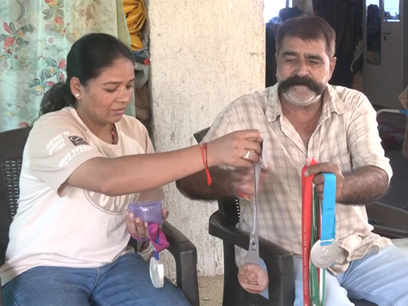 Manisha's father Kailash Keer and her elder sister Sona Keer showing previously won medials (Photo/ANI)