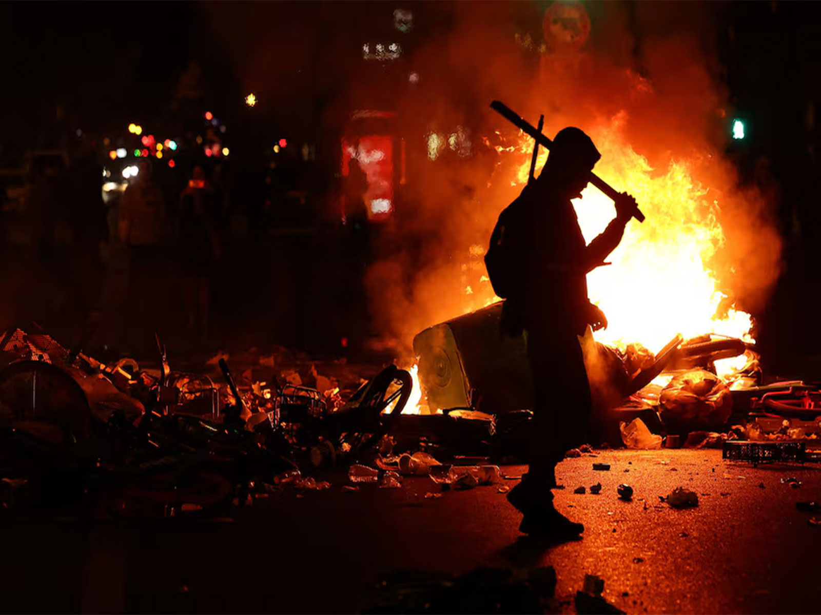 A person walks as flames rise during civil unrest, the day after a national day of demonstrations against the cost of living and rising fuel prices, in Paris, France (Photo/Reuters)
