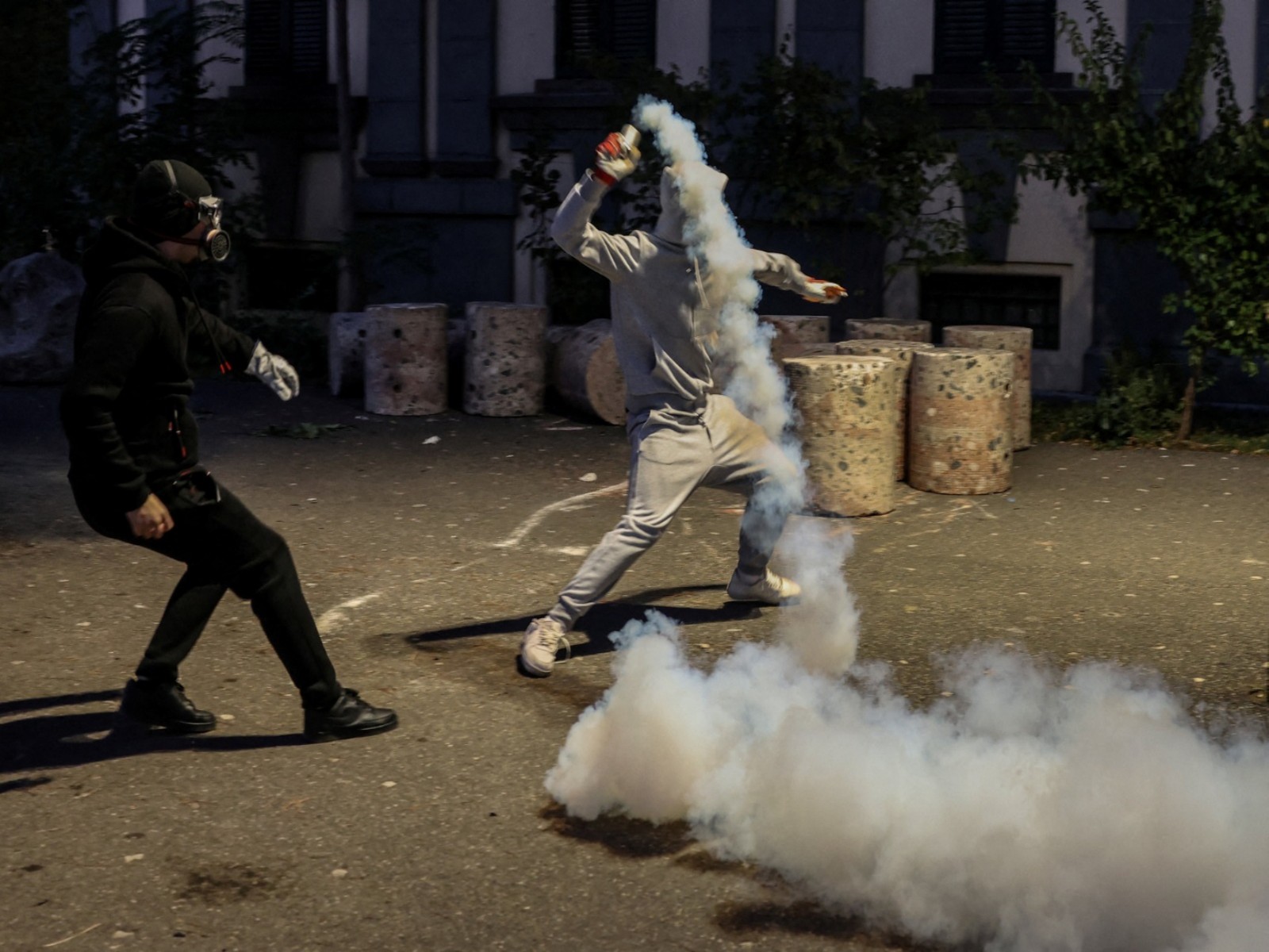 A protester throws a tear gas canister back towards police, during an anti-government protest by students in Tirana, Albania (Photo/Reuters)