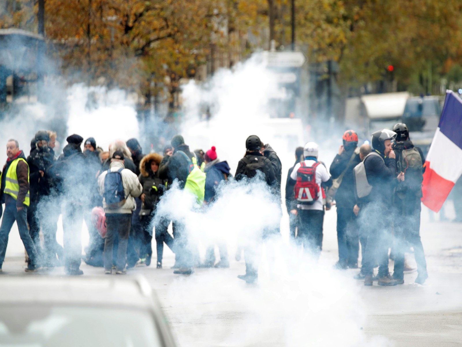 Protesters stand amidst tear gas fired by police during a demonstration (File Photo/Reuters)