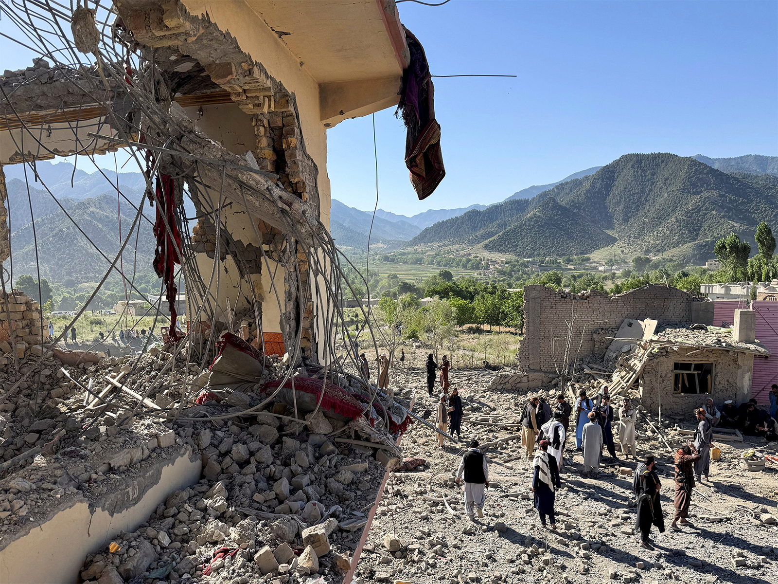 People gather near a destroyed building after an attack, which the Afghanistan say was an airstrike carried out by Pakistan's security forces, in Samkani District. (Photo/Reuters)