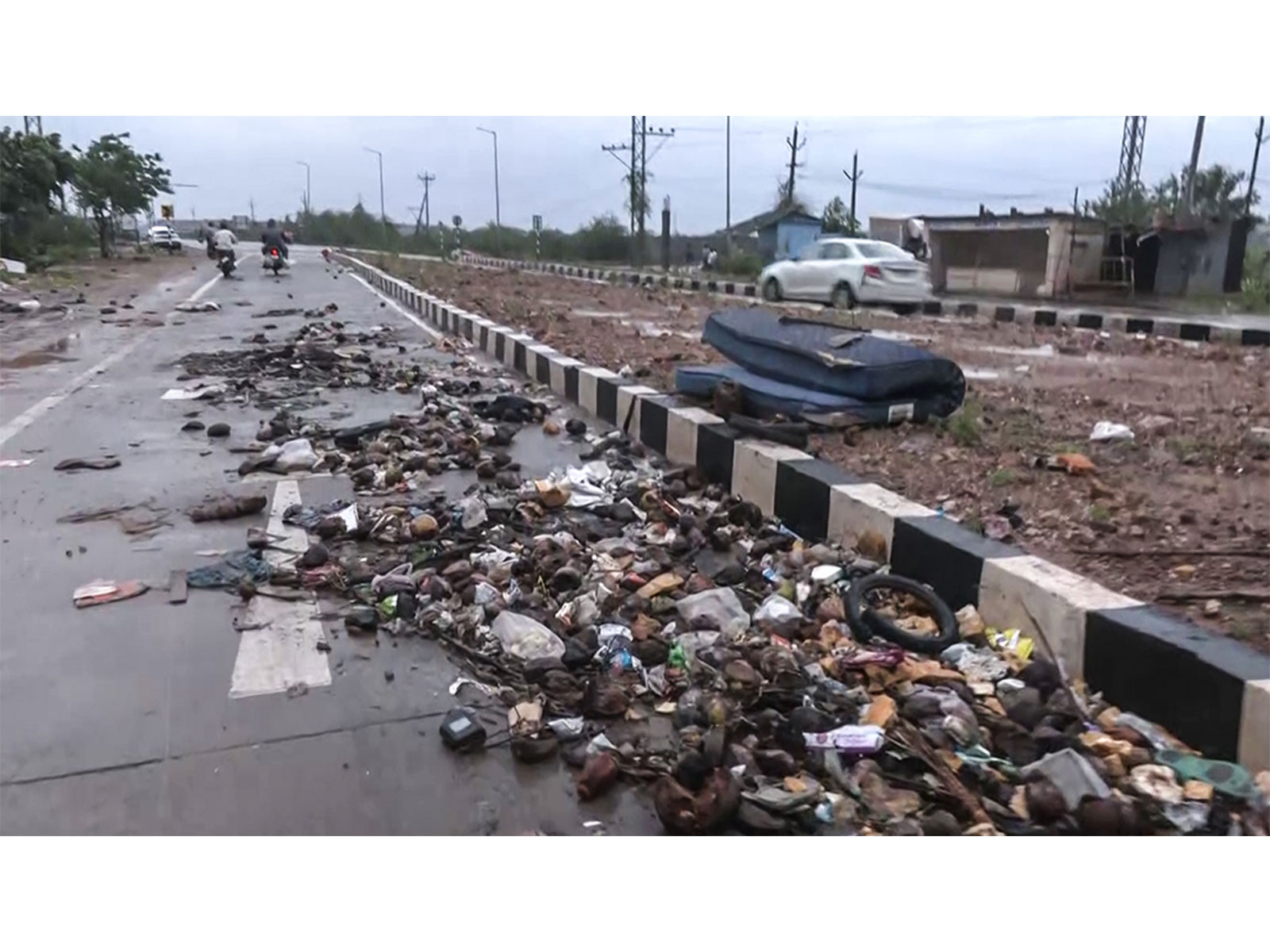 A view of debris including fallen coconuts, branches and other materials litters the roadside after strong winds from Cyclone Arnab battered the area, in Kakinada on Wednesday (File Photo/ANI)