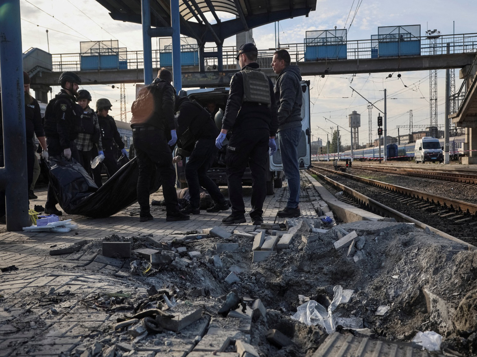 Police officers carry the body of a person at a railway station hit by a Russian drone strike in Ukraine (Photo/Reuters) 