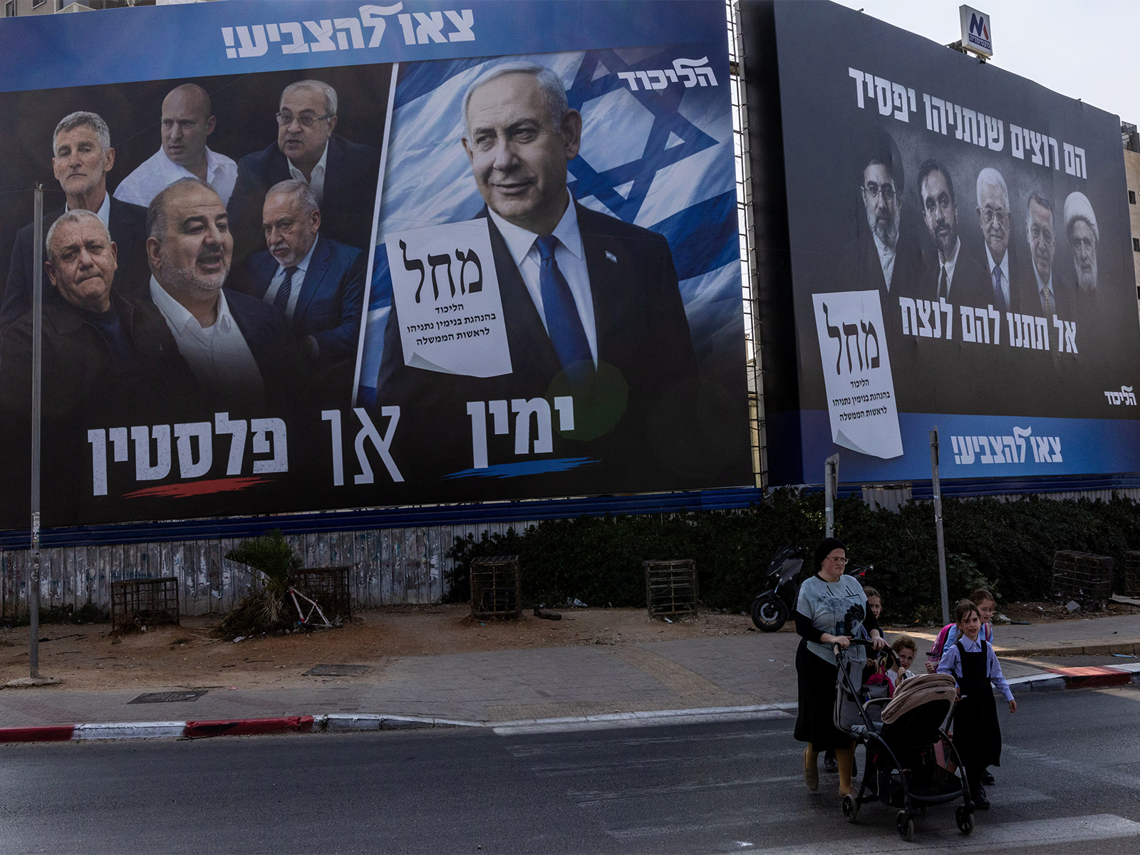People walk next to a campaign banner of Netanyahu's Likud party in Bnei Brak, Israel (File Photo/Reuters)