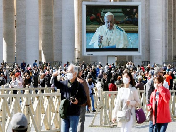 People in face masks walk on St. Peter's Square as Pope Francis delivers his weekly Angelus prayer transmitted via video People in face masks walk on St. Peter's Square as Pope Francis delivers his weekly Angelus prayer transmitted via video