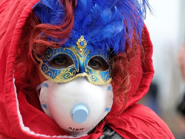 Masked Carnival reveler wearing a protective face mask at Venice Carnival, amid outbreak coronavirus, in Venice, Italy. Masked Carnival reveler wearing a protective face mask at Venice Carnival, amid outbreak coronavirus, in Venice, Italy.